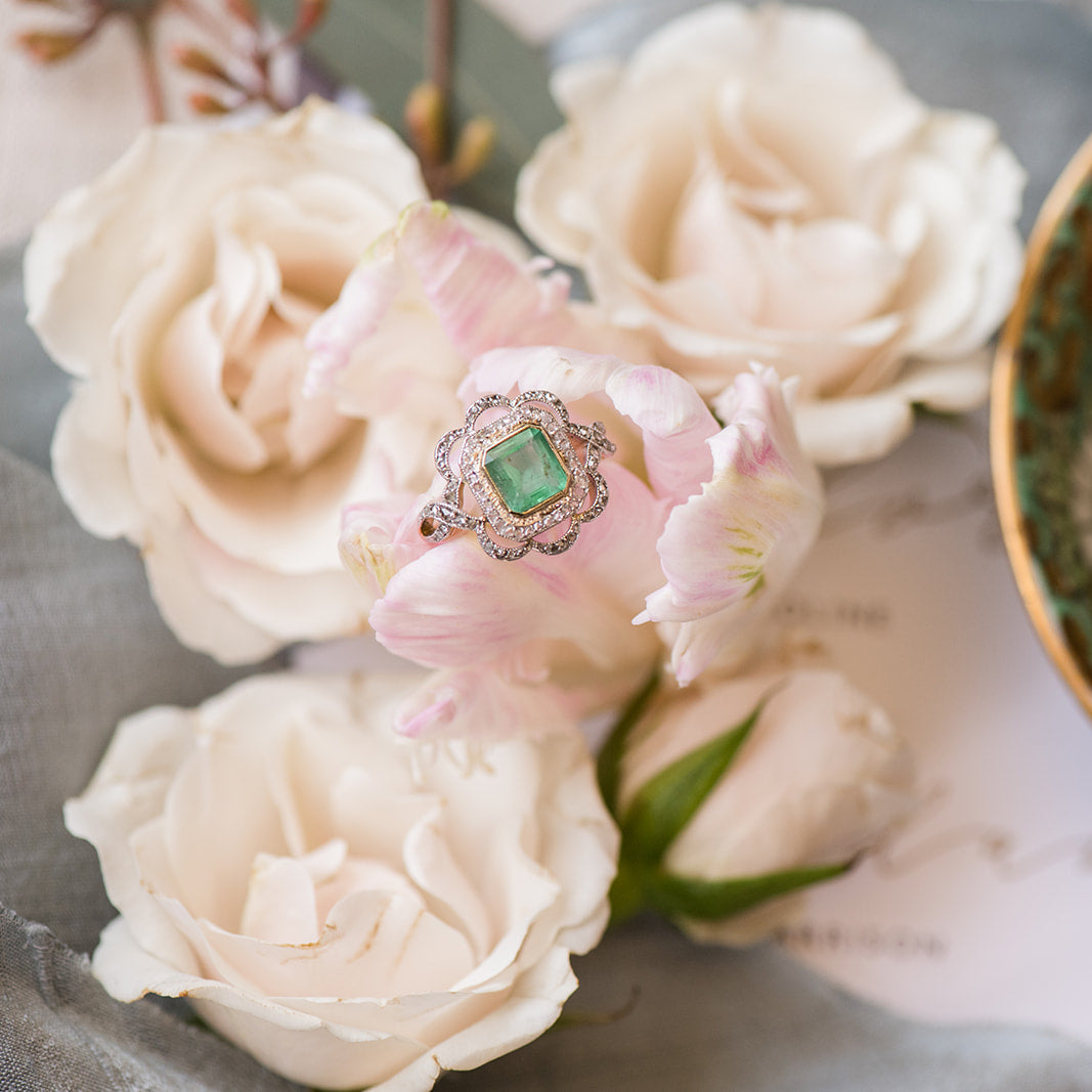 Estate emerald and diamond ring nestled in soft pink roses