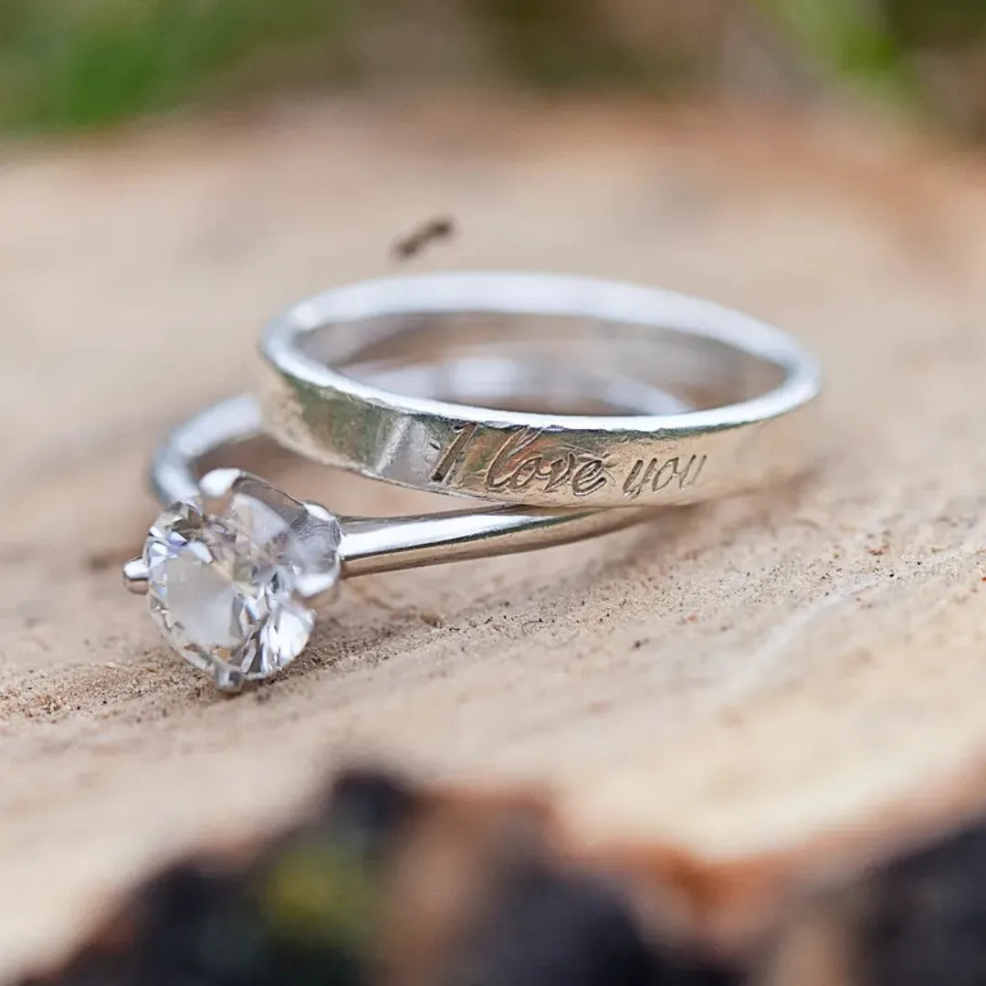 A diamond bridal set with an engraving on the wedding band saying "I love you" in script