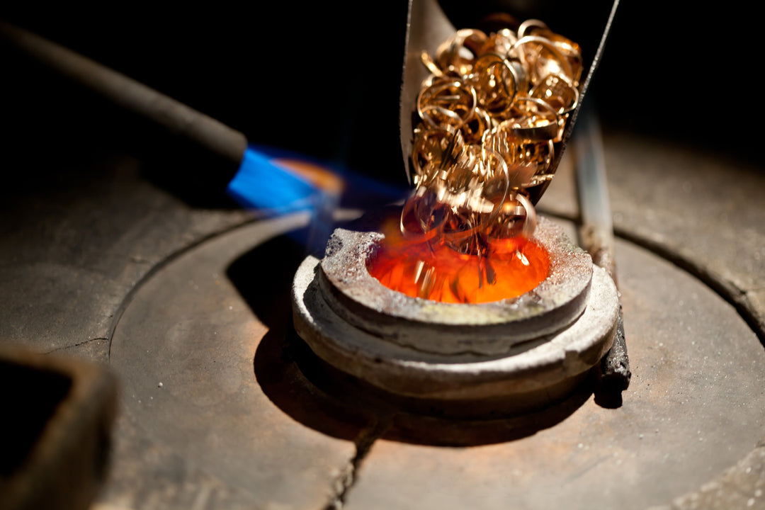 Gold jewelry being added to a furnace for melting