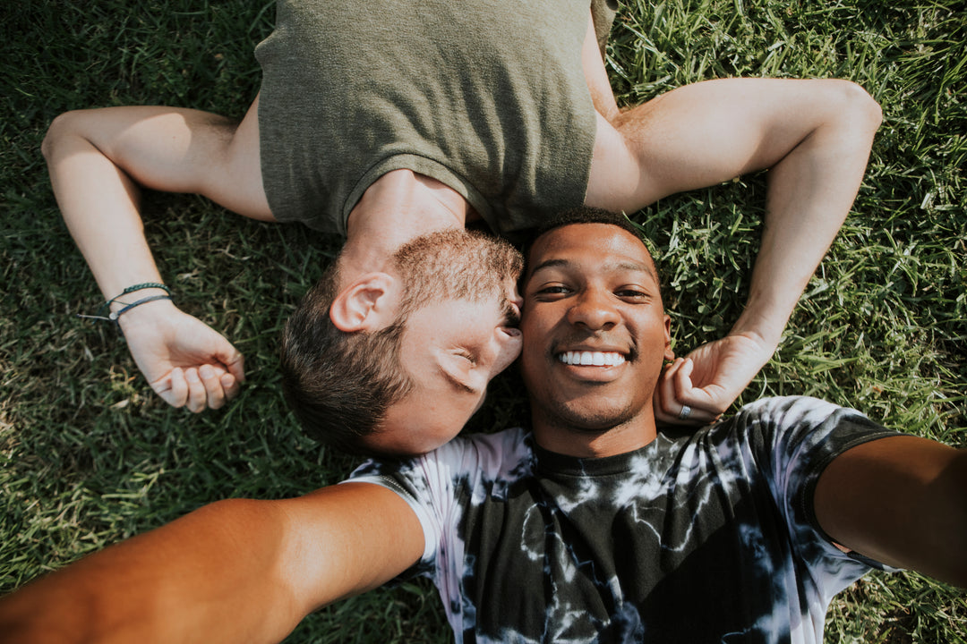 Happy couple laying in the grass and smiling