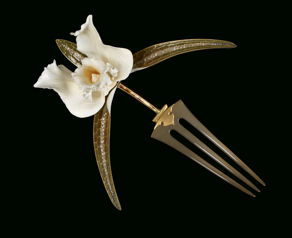 An Art Nouveau era orchid comb created by Rene Lalique using ivory, gold, "plique-au-jour" enamel, horn, and diamonds.