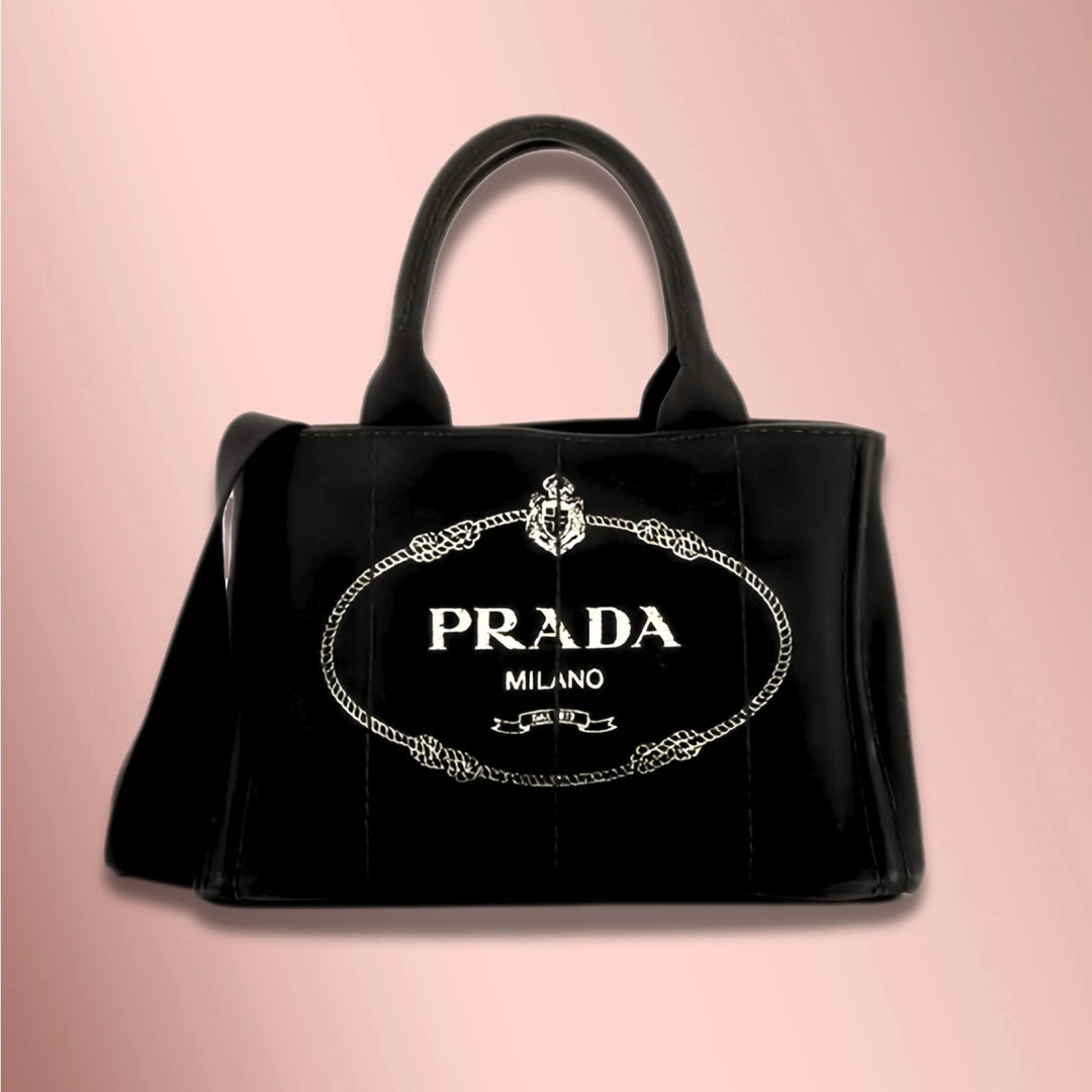 A black Prada brand vintage luxury handbag with white accents