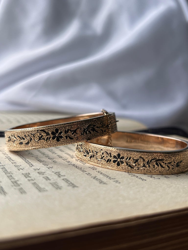 Estate Victorian enamel wedding bangles resting on top of an open book