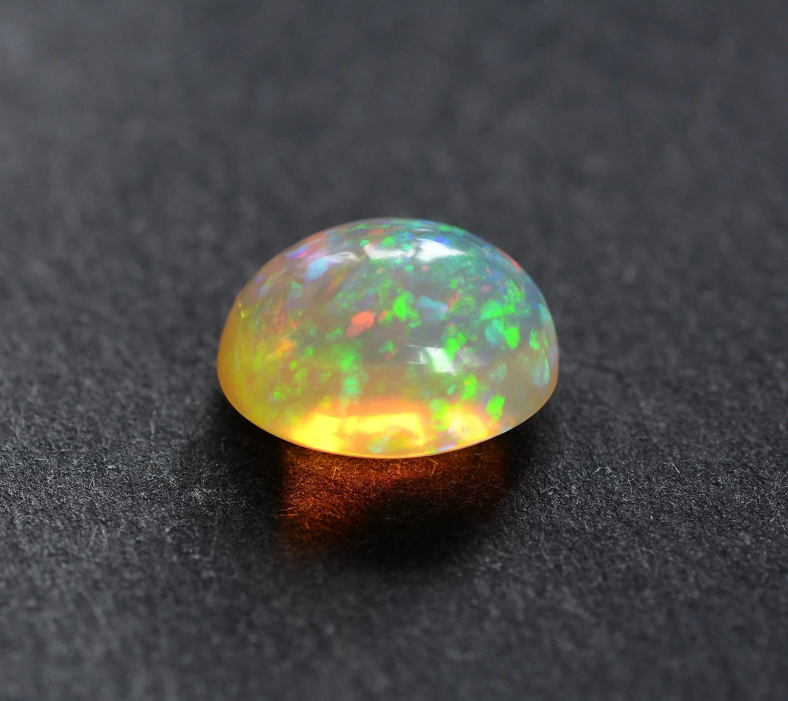 A welo opal on a dark textured background