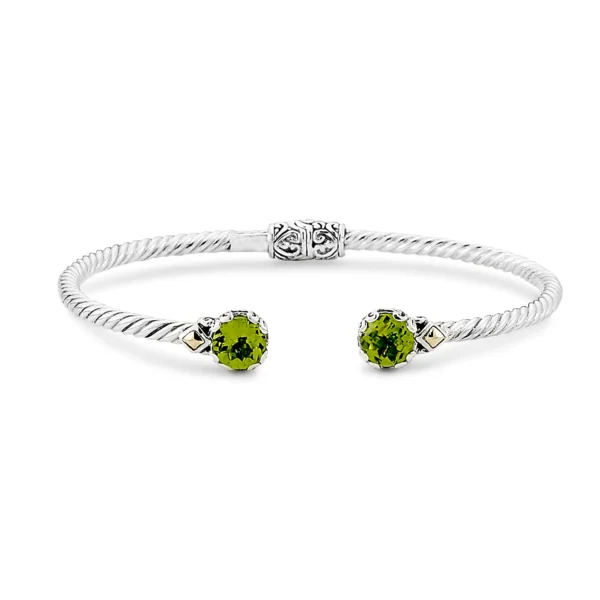 One sterling silver twisted cuff bangle bracelet with solid 18 karat yellow gold accents and 2 round peridots measuring 7mm set in each end