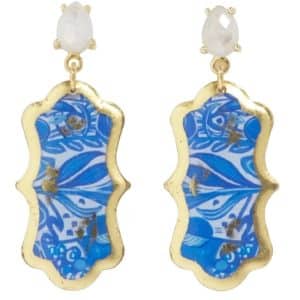 a pair of 22 karat yellow gold leaf finish drop earrings by Evocateur featuring pear-shaped multi-faceted moonstones that drop down to pendants inspired by traditional Dutch delftware accented by luscious cobalt blue flower and leaf shapes
