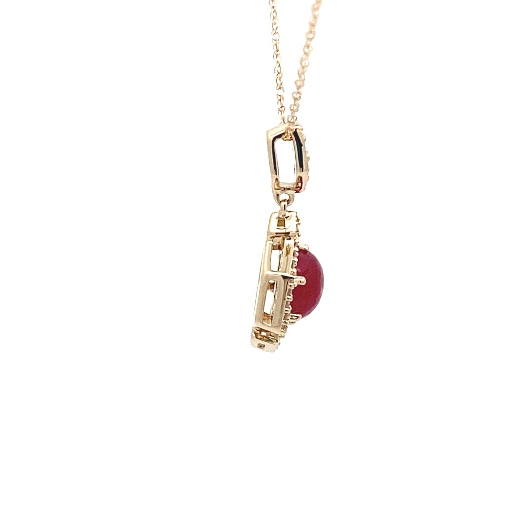 A 14 karat yellow gold pendant necklace with a round cabochon ruby and round diamond accents on a rope chain from the LoveFire Greenland Collection by Tache