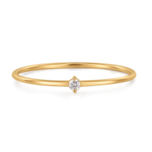 One 14 karat yellow gold Riya diamond solitaire ring by Aurelie Gi containing a round-faceted diamond weighing 0.027 carat in a two-prong setting. the band measures 0.9mm wide.