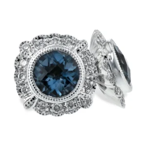 One pair of 14 karat white gold stud earrings containing 2 round-faceted London blue topazes weighing 1.03 carats total weight in a milgrain-accented bezel setting surrounded by a scalloped vintage-inspired halo set with round-faceted diamonds weighing 0.14 carat total weight