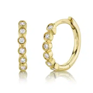 One pair of 14 karat yellow gold huggie hoop earrings featuring 10 round diamonds in scalloped bezel settings with milgrain accents.
