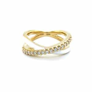 A yellow gold crossover ring with white enamel and diamonds
