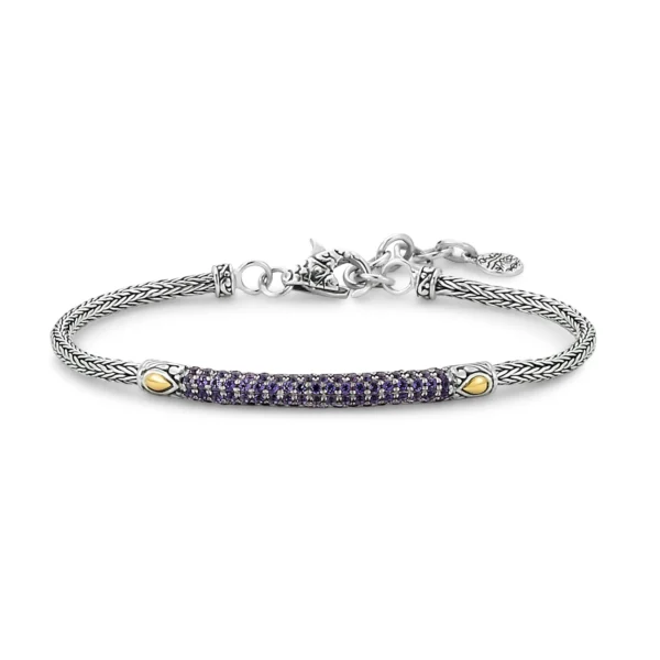 One sterling silver bracelet featuring a bar pave set with round-faceted amethysts and accented by solid 18 karat yellow gold. The bar is set on a tulang naga-style chain that is secured with a lobster claw clasp. Adjustable length.
