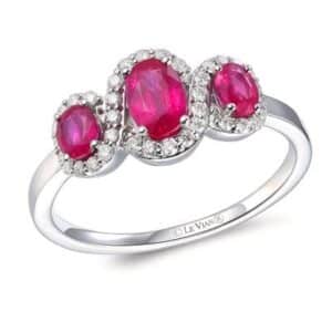 One 14 karat white gold three-stone ring by Le Vian with 3 oval rubies weighing 0.92 carat total weight and 19 round brilliant diamonds that create a halo that connects and twists around each ruby