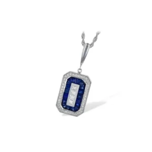 The Art Deco-Inspired Diamond and Sapphire Necklace by Allison Kaufman is a 14 karat white gold pendant necklace containing a rectangle-shaped pendant set a center 4 square diamonds in a channel setting surrounded by an emerald-shaped halo of 19 calibre cut blue sapphires weighing 0.33 carat total in a channel setting which is then surrounded by an outer emerald-shaped halo of round diamonds in pave settings with the outer edge accented with milgrain details. The pendant features a polished traditional bail and is suspended from an 18" rope chain. The pendant measures 17.40mm long x 11.70mm wide.