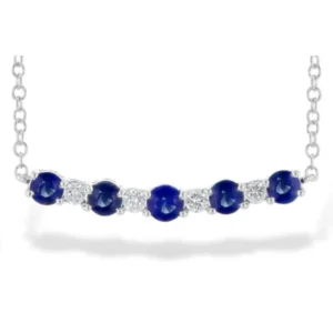 Blue Sapphire and Diamond Bar Necklace in 14 karat white gold. Features a slightly curved vertical bar pendant set with 5 round blue sapphires weighing 0.58 carat total weight and 4 round diamonds weighing 0.70 carat total weight in an alternating pattern. The pendant is fixed on a chain measuring 18" long.