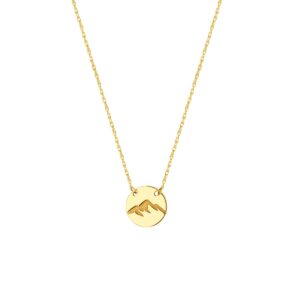 A yellow gold necklace with a round disc charm with an etched mountain image