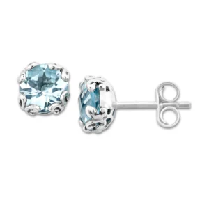 One pair of sterling silver stud earrings containing 2 round-shaped checkerboard-faceted blue topazes measuring 7mm each in ornate prong settings. Secured with friction posts and backs.