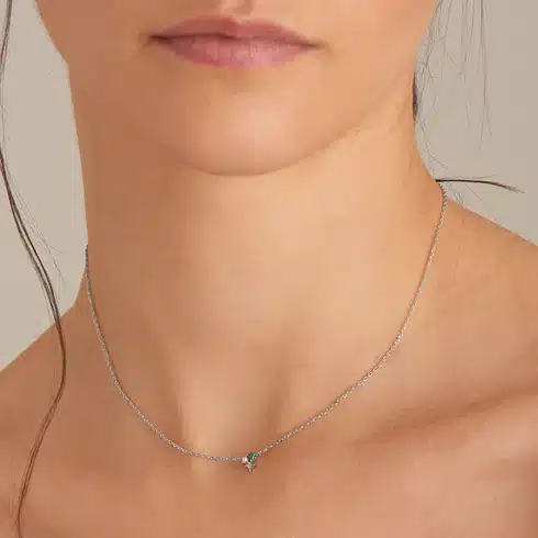 A model wearing a sterling silver necklace set with malchite, a pearl, and a cubic zirconia