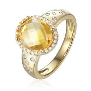 A yellow gold statement-style ring featuring an oval faceted citrine with diamonds in a halo and in the band