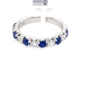 A white gold wedding-style straight band set with alternating round blue sapphires and diamonds