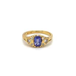 One estate 18 karat yellow gold Edwardian-inspired ring with an oval tanzanite and 6 accent diamond weighing 0.25 carat total weight