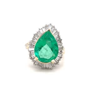One estate vintage 14 karat two-tone gold ring with a pear-shaped emerald and a baguette diamond halo