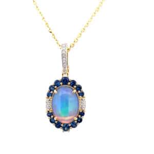 One 14 karat yellow gold pendant necklace featuring an oval cabochon opal surrounded by a halo of round blue sapphire and diamond with diamonds in the bail on a yellow gold chain
