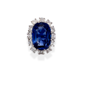 One platinum blue sapphire and diamond ring containing a center oval blue sapphire weighing 13 carats and and 12 oval diamonds weighing 2.41 carats in a segemented halo around the sapphire.