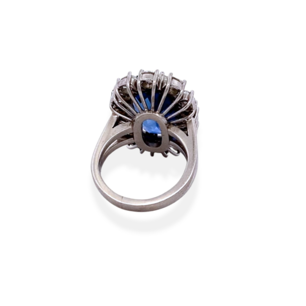 One platinum blue sapphire and diamond ring containing a center oval blue sapphire weighing 13 carats and and 12 oval diamonds weighing 2.41 carats in a segemented halo around the sapphire.
