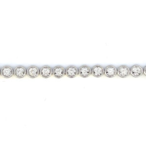 One estate 14 karat white gold diamond tennis bracelet with 36 modern round brilliant diamonds weighing 1.50 carats in round illusion settings with a length of 7"