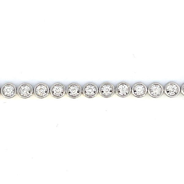 One estate 14 karat white gold diamond tennis bracelet with 36 modern round brilliant diamonds weighing 1.50 carats in round illusion settings with a length of 7"