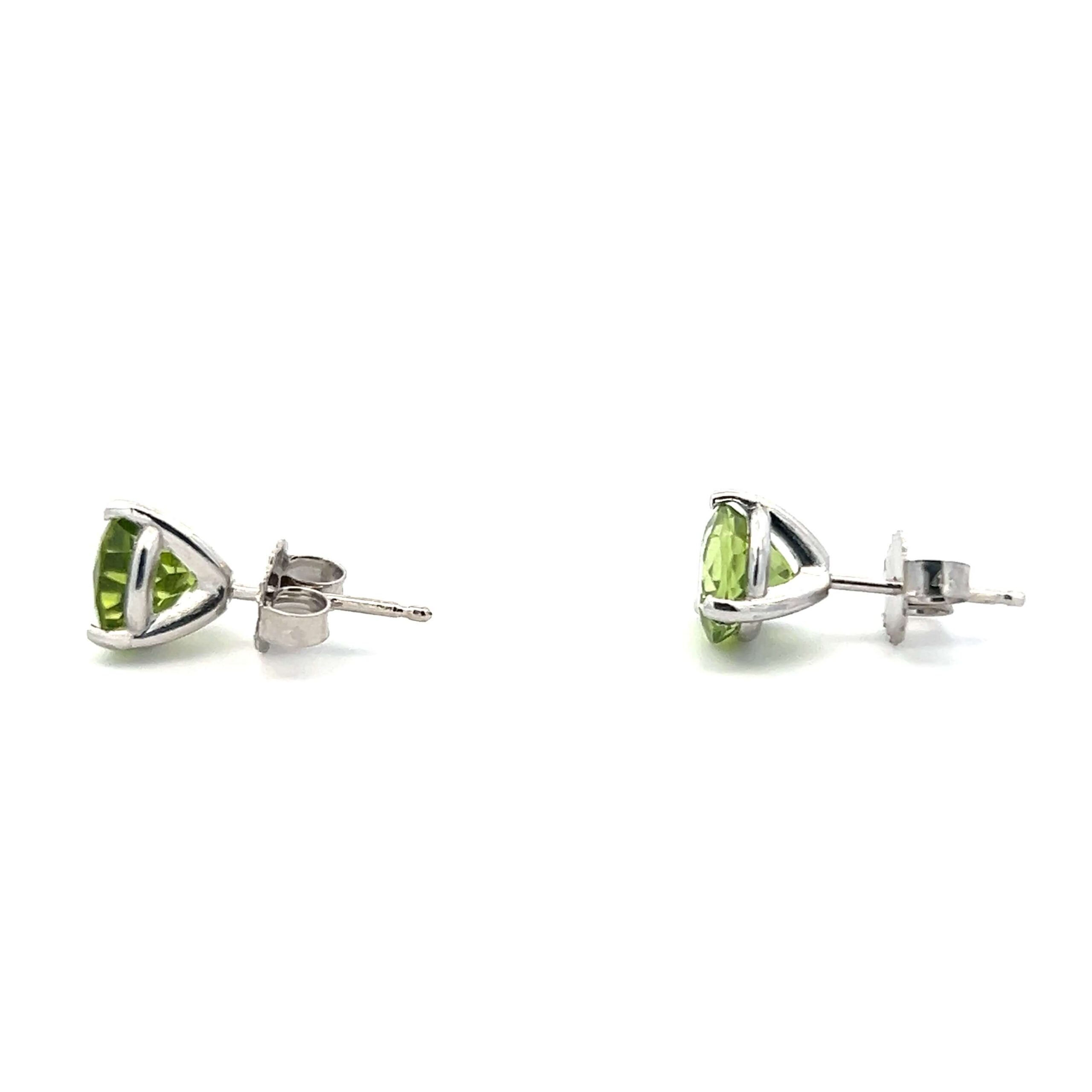 One estate pair of 14 karat white gold stud earrings with 6.5mm round-faceted peridots in three-prong settings