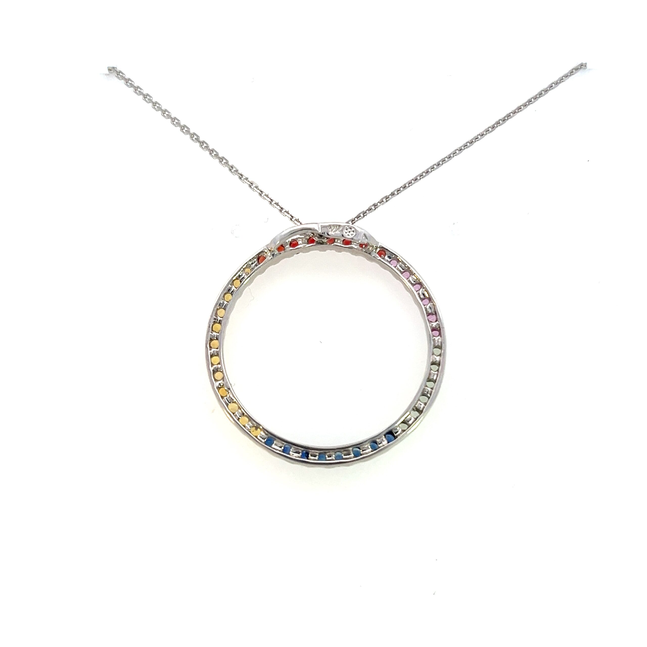One estate 14 karat white gold pendant necklace with a 25mm open circle pendant set with 39 round-faceted sapphires in various hues including pink, orange, yellow, and blue measuring 2mm each