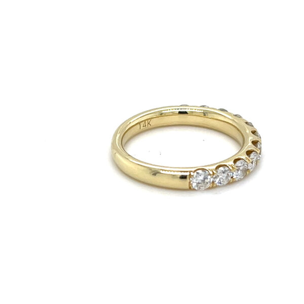 an estate 14 karat yellow gold wedding-style band with 11 round brilliant diamonds weighing 1 carat in prong settings.