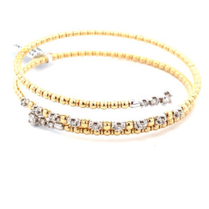 A two-tone gold bead-style wrap bracelet with diamond end caps and set in part of the middle row