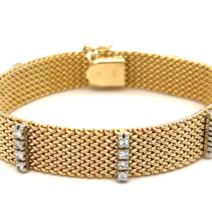 An estate 14 karat yellow gold mesh bracelet with 7 stations of 4 sparkling diamonds.