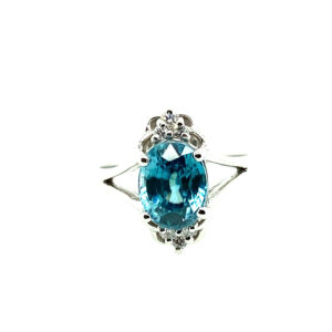 An estate 14 karat white gold fashion ring with an oval blue zircon and diamond accents