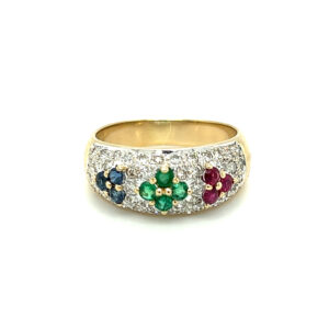 An estate 18 karat yellow gold fashion band featuring a cluster of blue sapphires, emeralds, and rubies with diamond accents