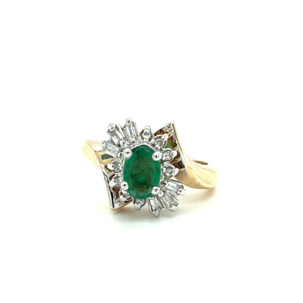 An estate vintage 14 karat gold halo bypass ring with an oval emerald and round and baguette diamonds in the halo