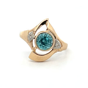 An estate vintage 14 karat two-tone gold open-style abstract ring with a 7.5mm round blue zircon and 2 round diamond accents