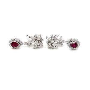 One pair of estate 14 karat white gold drop earrings with ruby drop pendants surrounded by diamond halos and diamond flower motifs at the post area