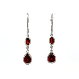A pair of estate 14 karat white gold drop earrings each set with a pear-shaped garnet and an oval garnet with a single diamond accent