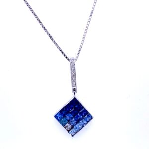 An estate 14 karat white gold drop pendant necklace featuring a square-shaped pendant set with princess-cut blue sapphires in gradient colors and diamond accents in the bail