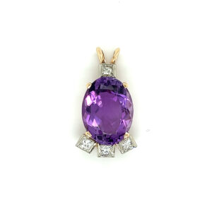 An estate 14 karat gold pendant with an oval amethyst and 4 diamond accents
