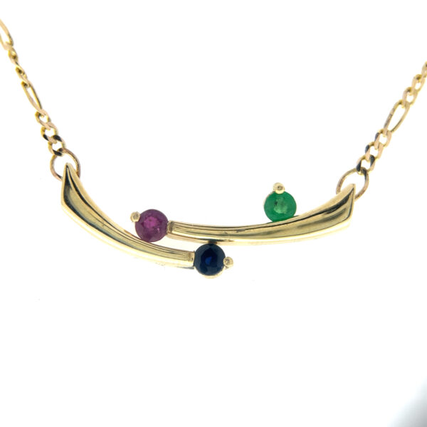 An estate 14 karat yellow gold bypass bar necklace set with a round ruby, emerald, and blue sapphire