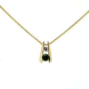 One estate 14 karat yellow gold pendant necklace featuring a slide pendant with a round green tanzanite and a round diamond