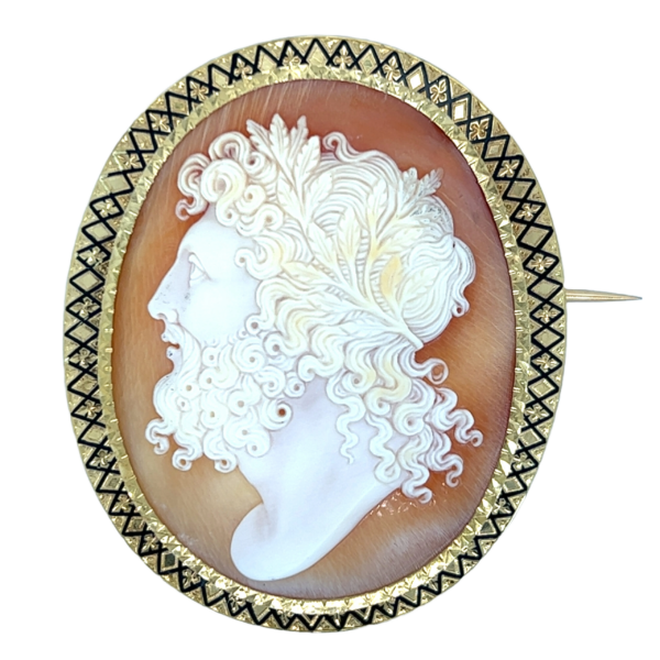 An estate antique Victorian brooch with a carved shell cameo and a gold frame with black enamel accents