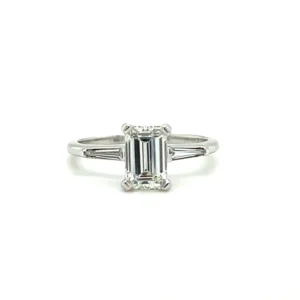 One estate 18 karat white gold engagement ring with a center emerald-cut diamond weighing 1.01 carats flanked on either side by a tapered baguette diamond