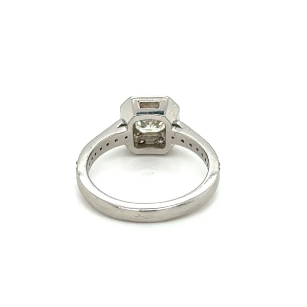 One estate plantium halo engagement ring with a center radiant-cut diamond weighing 0.75 carat and 24 round brilliant accent diamonds weighing 0.28 carat total weight set in the halo and in the band