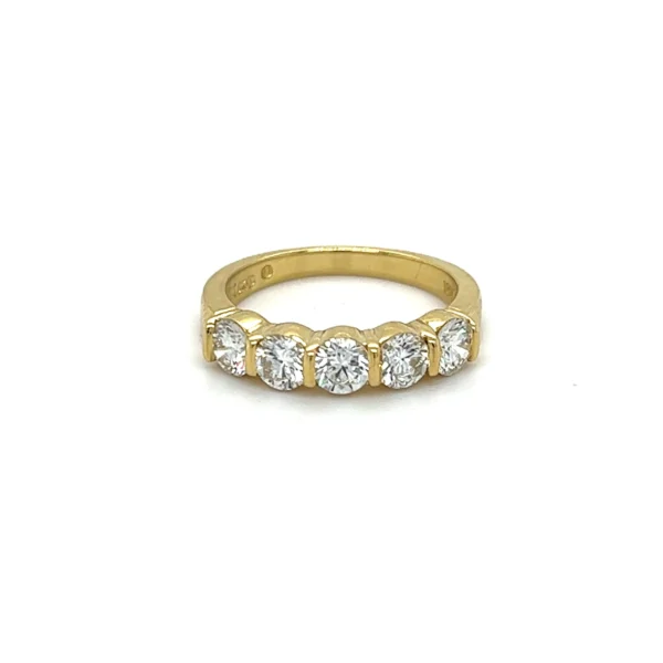 One estate 18 karat yellow gold wedding band with 5 round brilliant diamonds weighing 1.00 carats total weight in prong settings